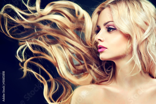 Beautiful model with flying long blonde hair .