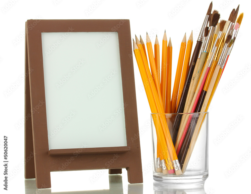 Photo frame as easel with artist's tools isolated on white Photo frame as easel with artist's tools isolated on white