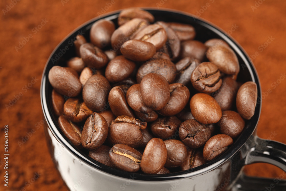 Black Cup with Coffee Beans on Coffee Powder Black Cup with Coffee Beans on Coffee Powder