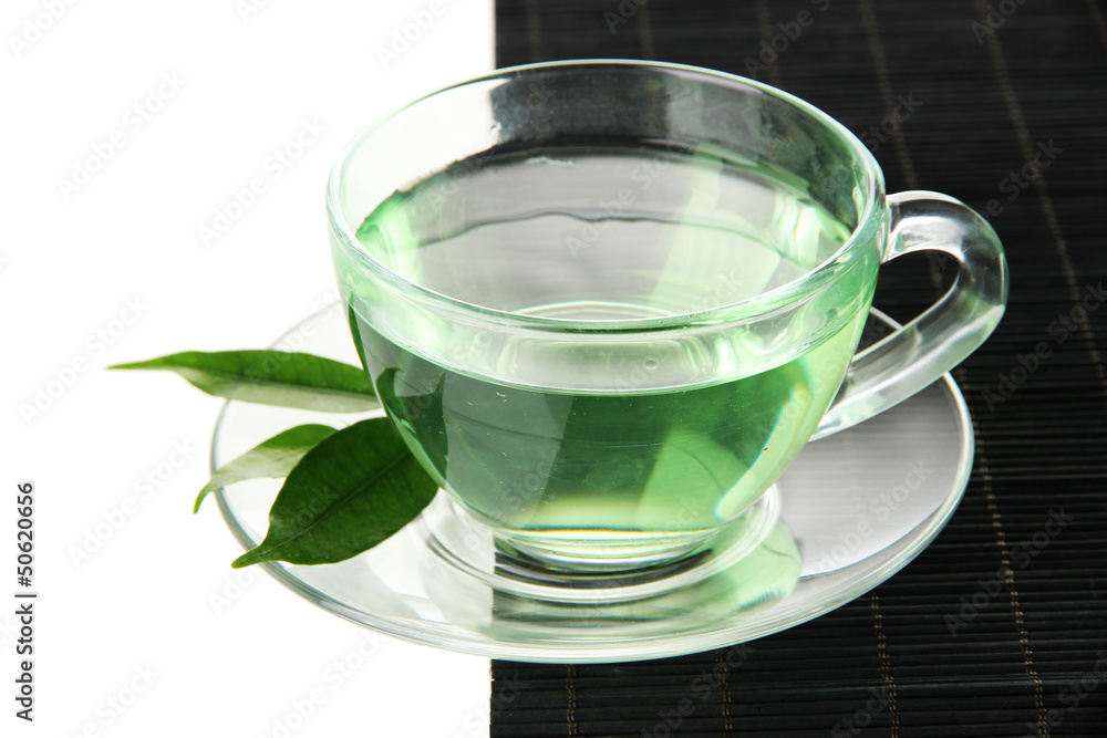 Transparent cup of green tea on bamboo mat, isolated on white