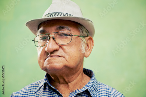 Portrait of serious old man with hat looking at camera © Diego Cervo