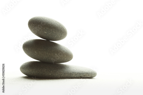 Three smooth stones on sand