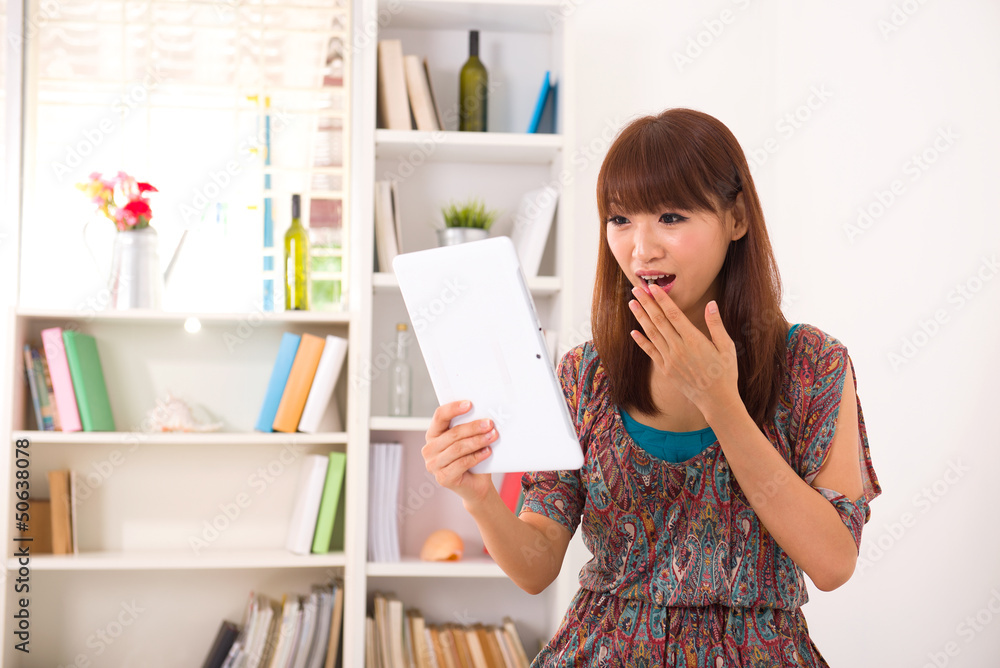 Portrait of smiling chinese woman using laptop with livingroom b