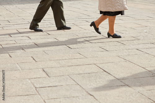 Feet of elderly couple walking on the street. Italy. Europe.