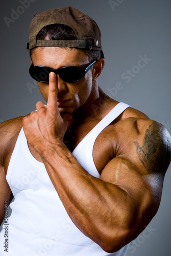 Handsome athletic man adjusts his sunglasses