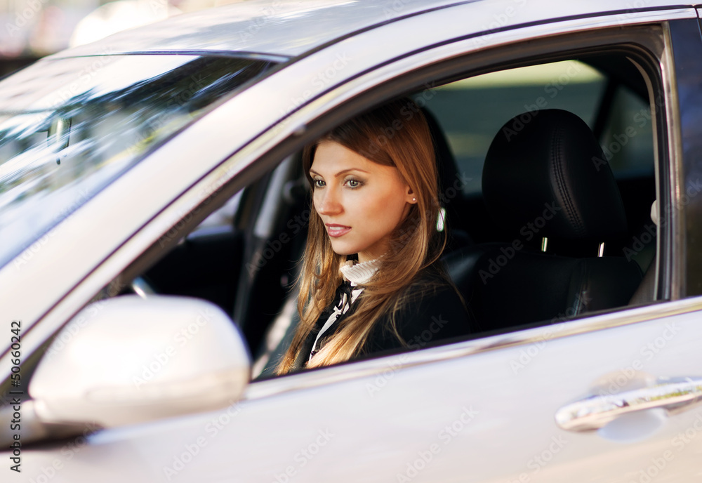 Beautiful young girl driving car