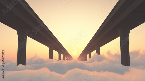 Two highways above clouds heading into a sunset
