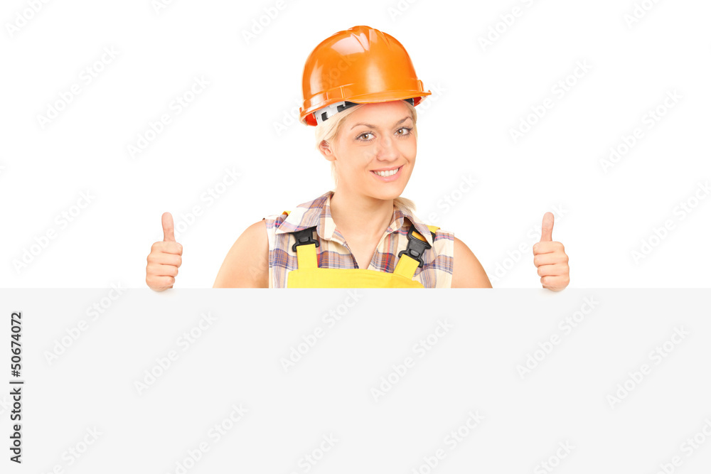 Young female with helmet posing behind a panel with thumbs up Young female with helmet posing behind a panel with thumbs up
