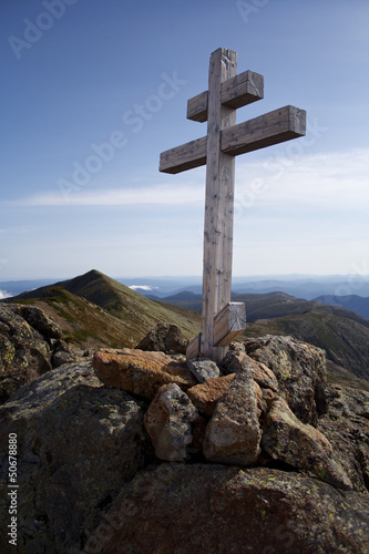 mountain cross with bit mountains in the background