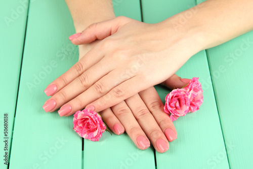 Woman hands with pink manicure and flowers,