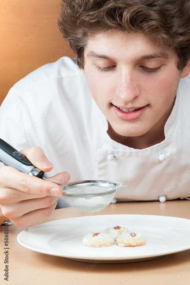 Young culinary specialist-confectioner strews cakes Young culinary specialist-confectioner strews cakes