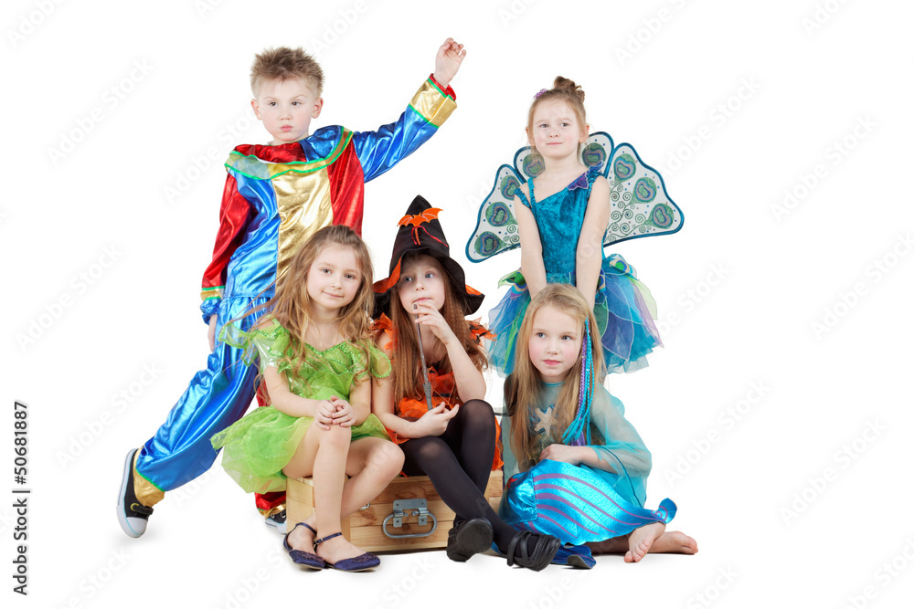 Children in carnival costumes sit on chest and stand beside