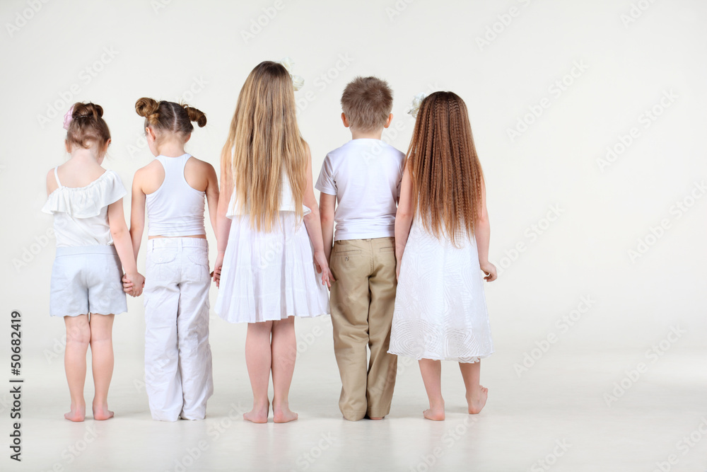 Naklejka premium Back of four cute little girls and one boy in white clothes