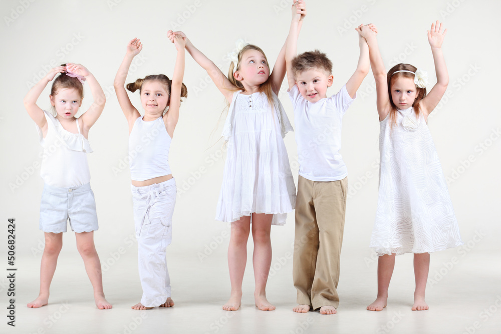 Naklejka premium Four cute little girls and one boy in white clothes