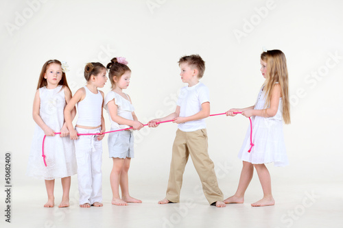 Four disputing little girls and one boy draw over rope