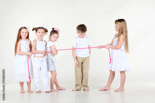 Four little girls draw over pink rope and boy
