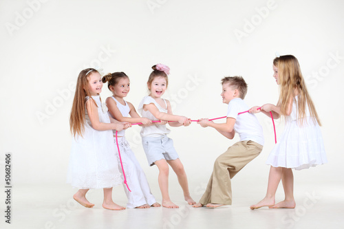 Five happy little children in white clothes draw over pink rope.