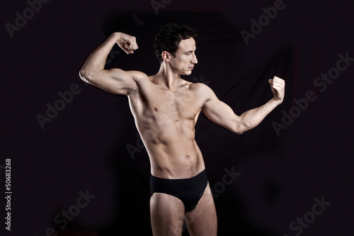 Handsome muscular guy on black background