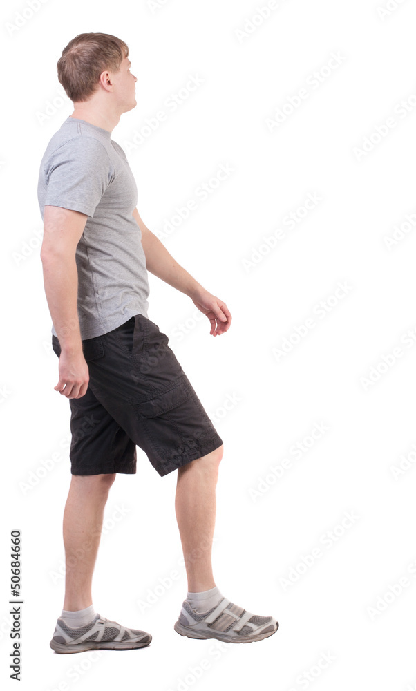 Back view of walking handsome man in shorts and sneakers Back view of walking handsome man in shorts and sneakers