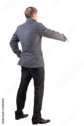 back view of businessman in coat reaches out to shake hands