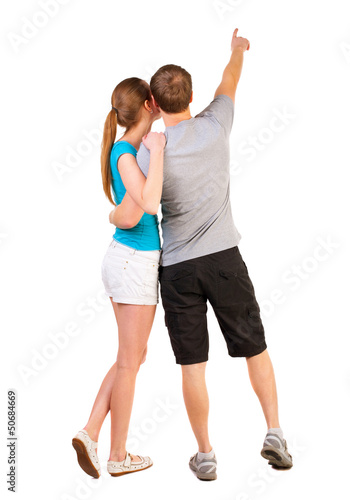 Back view of young couple pointing at wall
