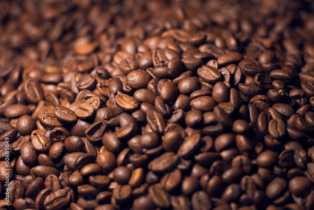 Blurred heap of coffee beans with narrow focus