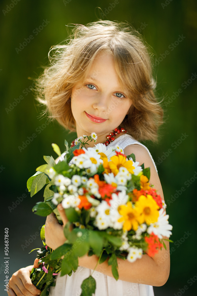 Smiling girl with bunch of wildflowers standing outdoors Smiling girl with bunch of wildflowers standing outdoors