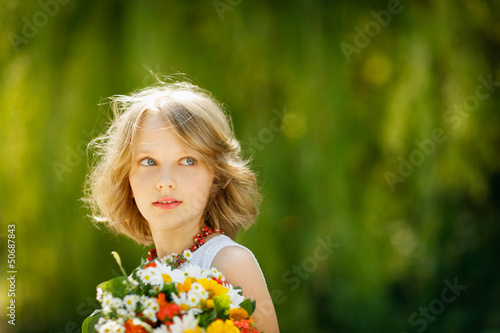 Girl with bunch of flowers outdoors looking to blank copy space