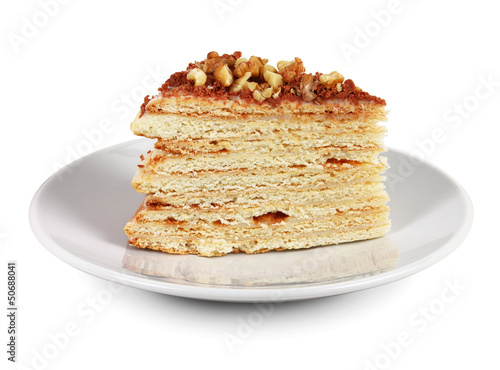 Piece of cake with nuts and chocolate crumbs on white plate