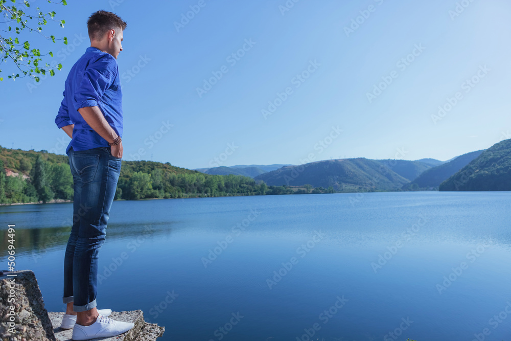 Naklejka premium casual man stands near lake