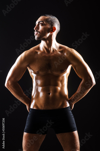 Muscular man in dark studio