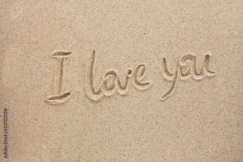 The word i love you written on the sand © alekleks