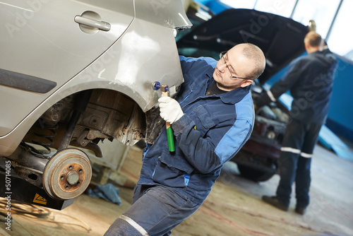 Fotografie auto repair man flatten metal body car