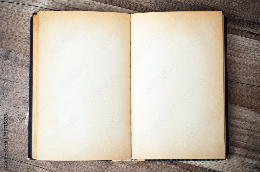 open old book on a wooden surface open old book on a wooden surface