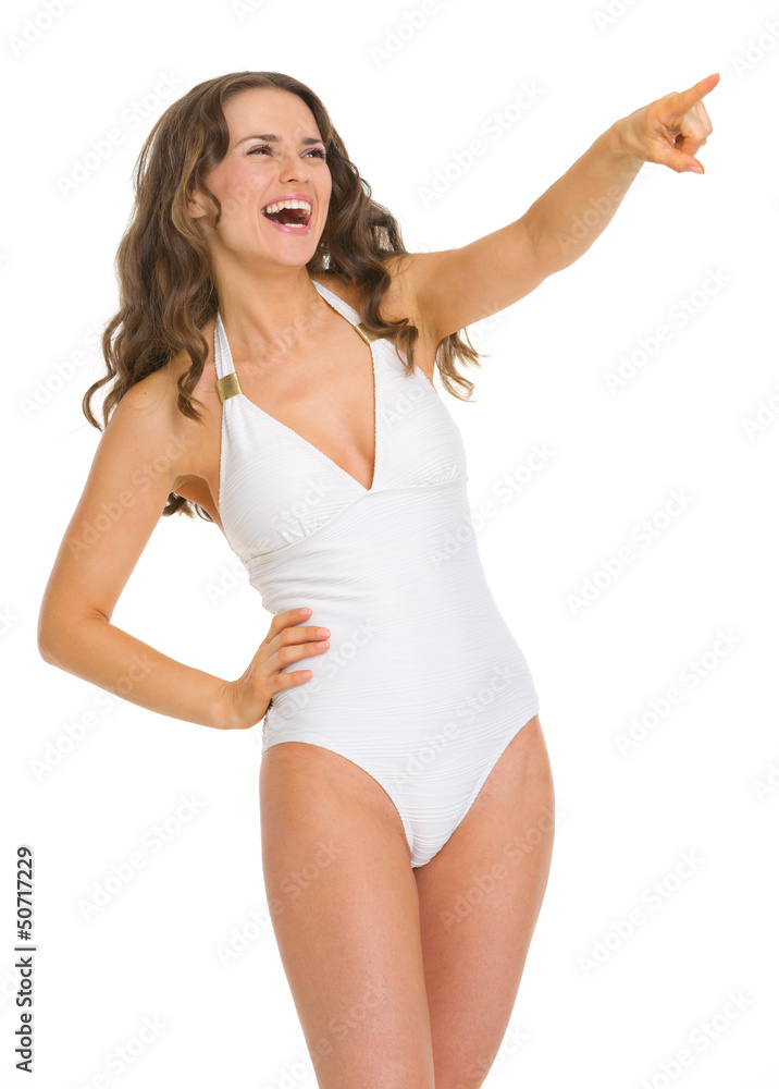 Portrait of young woman in swimsuit pointing on copy space Portrait of young woman in swimsuit pointing on copy space