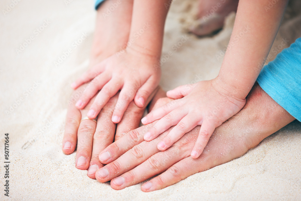 Father and daughter hands on sand Father and daughter hands on sand