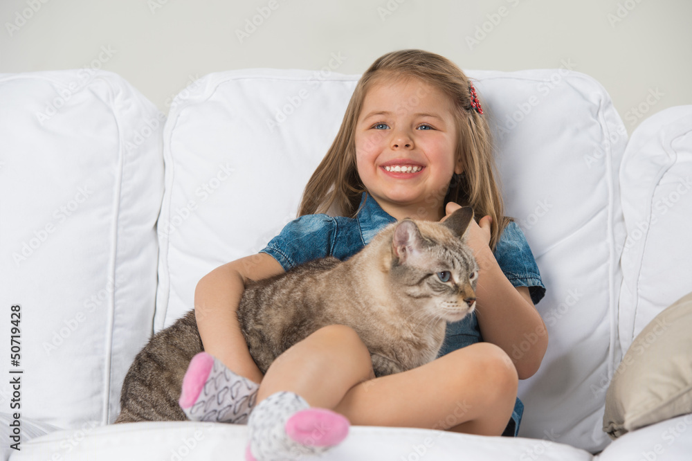 Cute little girl hugging tabby cat with love, looking away. Cute little girl hugging tabby cat with love, looking away.