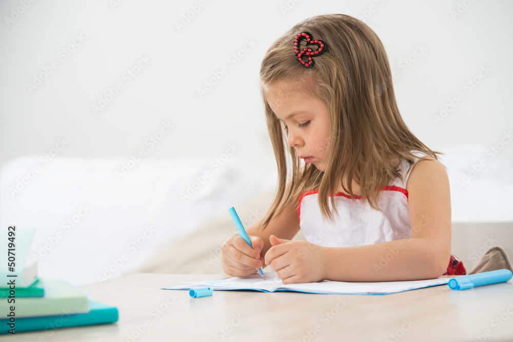 Happy little girl drawing with pencils at home Happy little girl drawing with pencils at home