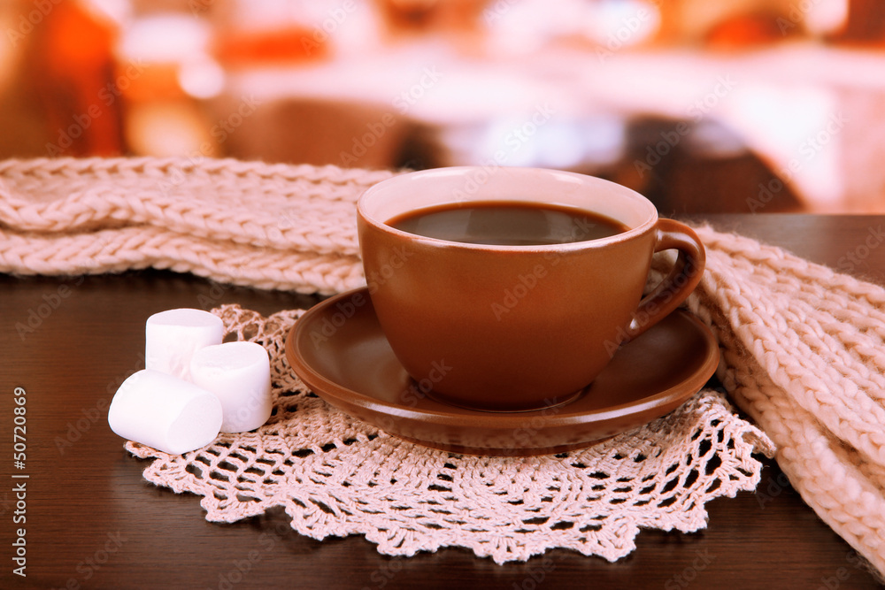 cup of coffee with scarf on table in room cup of coffee with scarf on table in room