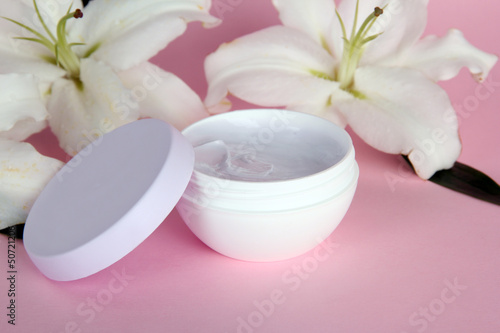 Cosmetic cream and beautiful lily, on pink background