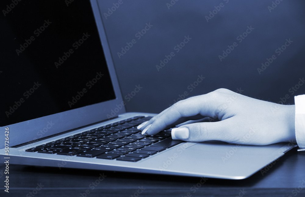 Female hands typing on laptot in blue light close-up Female hands typing on laptot in blue light close-up