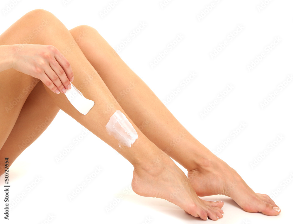 Beautiful woman legs with depilation cream, isolated on white Beautiful woman legs with depilation cream, isolated on white