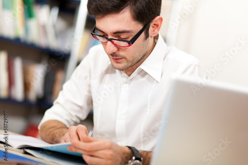 Student reading a book in a library