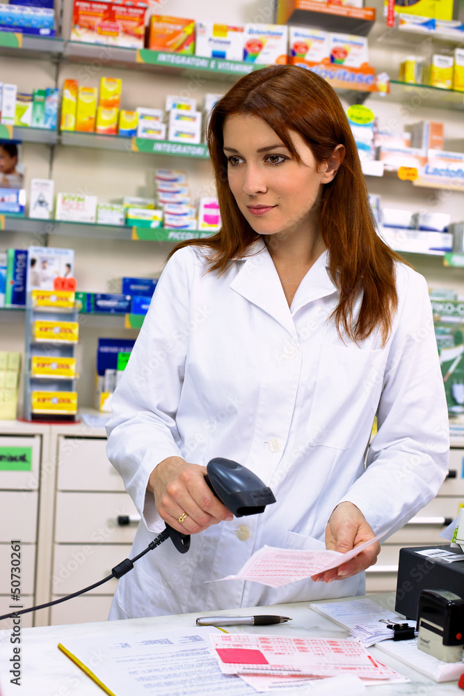 Gorgeous redhead pharmacist working with prescription