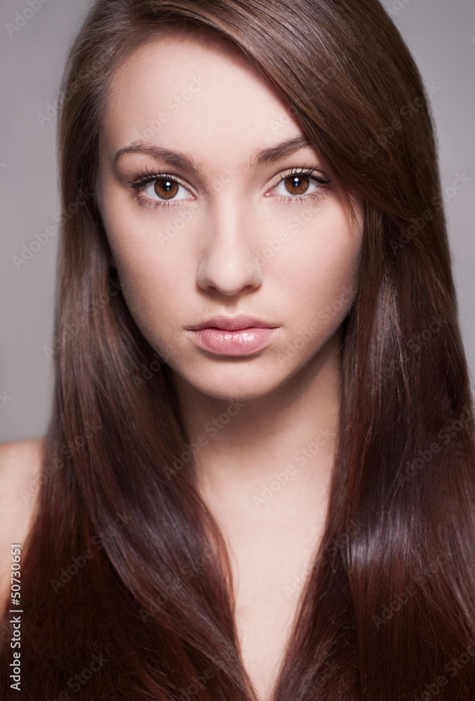 A woman with beautiful hair. Isolated on gray background A woman with beautiful hair. Isolated on gray background