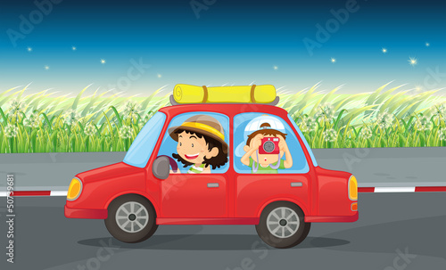 A girl and a boy riding in a red car
