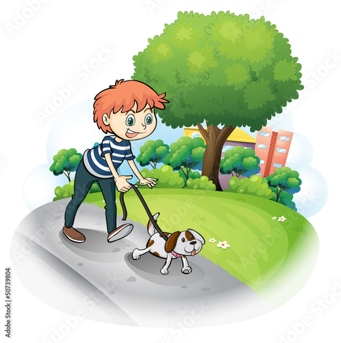 A boy walking with his dog along the street