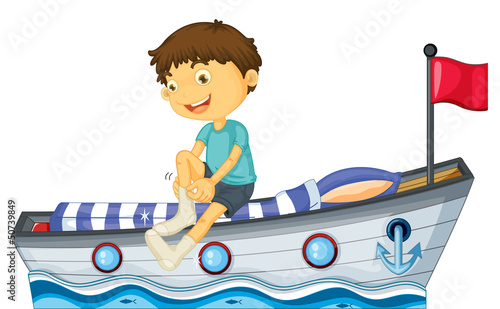 A boy sitting in the boat fixing his sock