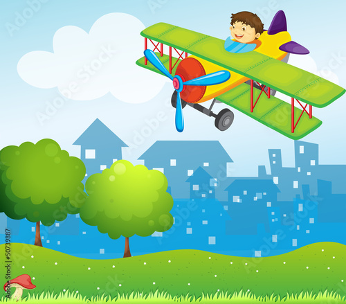 A boy riding in a plane above the hill