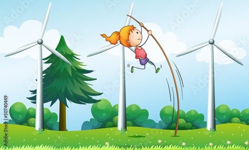 A young girl playing near the windmills